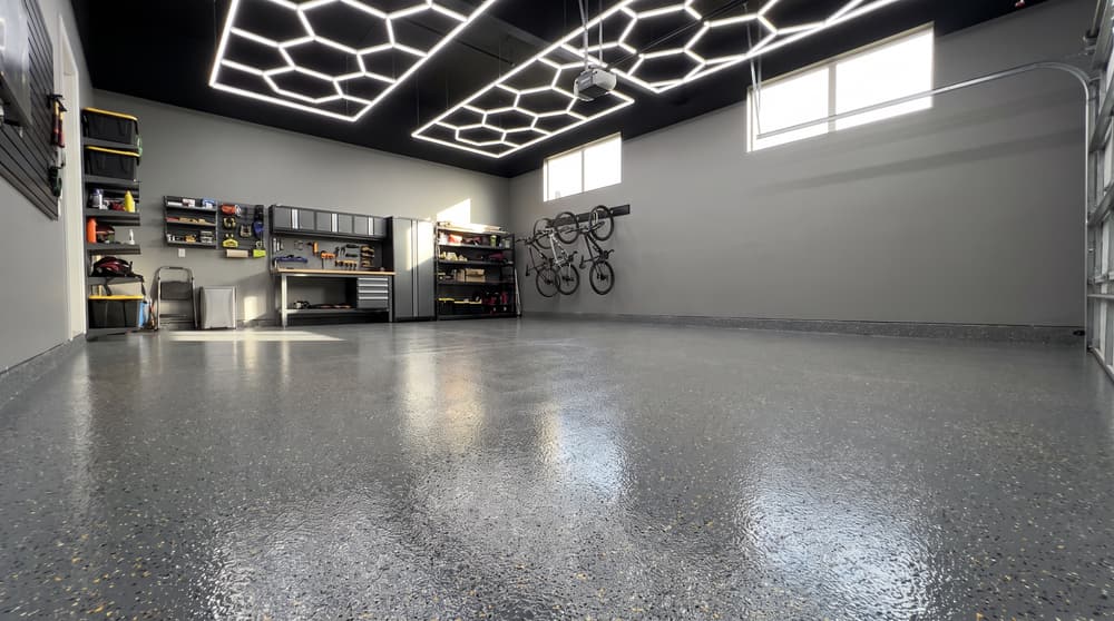 Shop garage with gray flake epoxy floor reflecting hexagon LED lighting